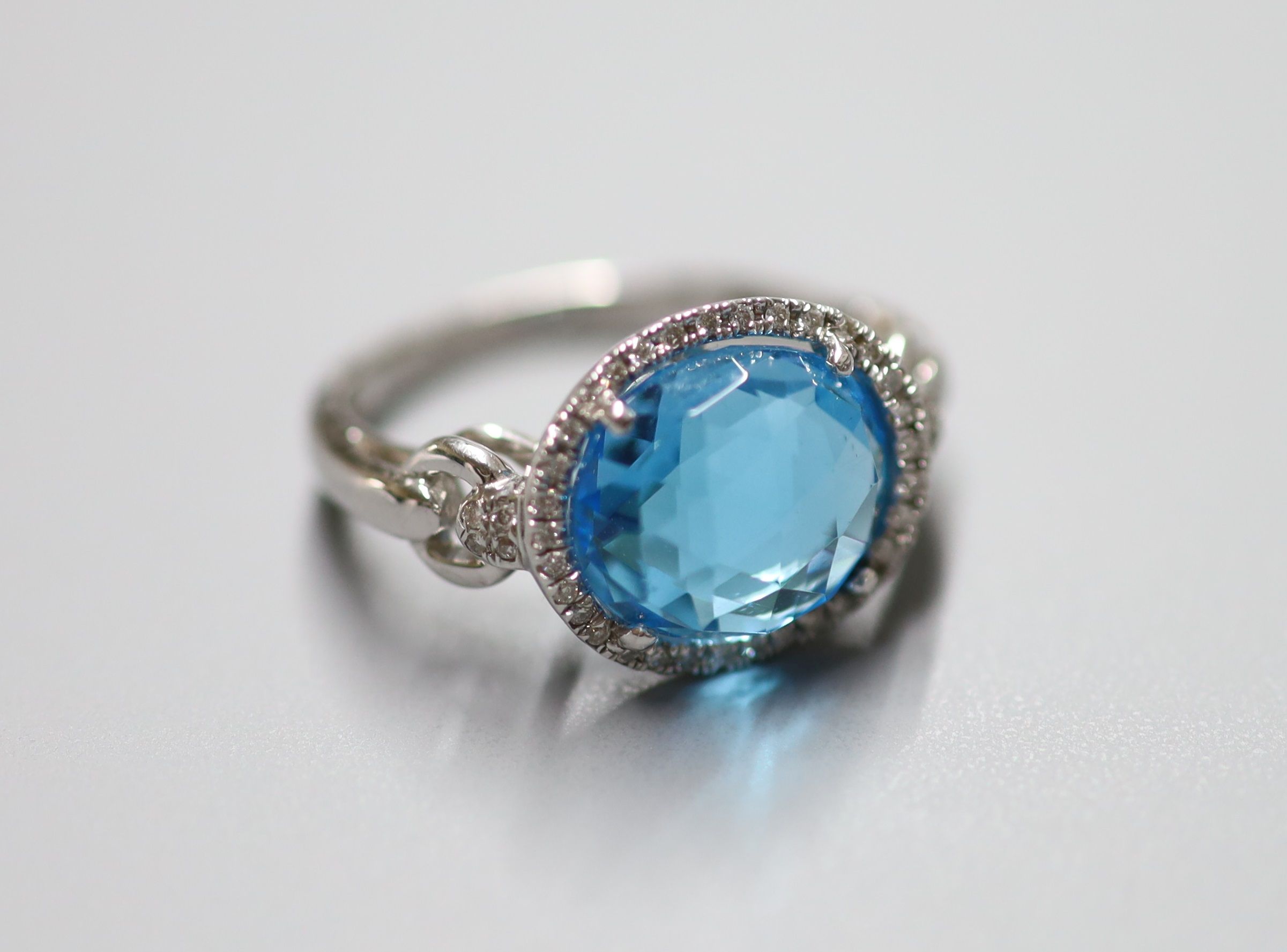 A modern 18ct white gold, blue topaz and diamond chip set dress ring, size L/M, gross 5 grams and a similar pair of drop earrings, stamped 375, gross 5 grams.